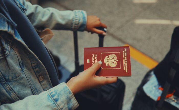 Traveler holding passport at airport for UAE visit visa application