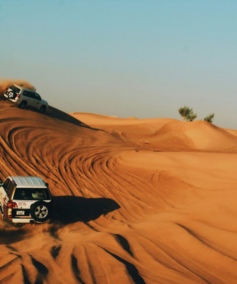 Dubai desert safari dune bashing with 4x4 vehicles in sand dunes