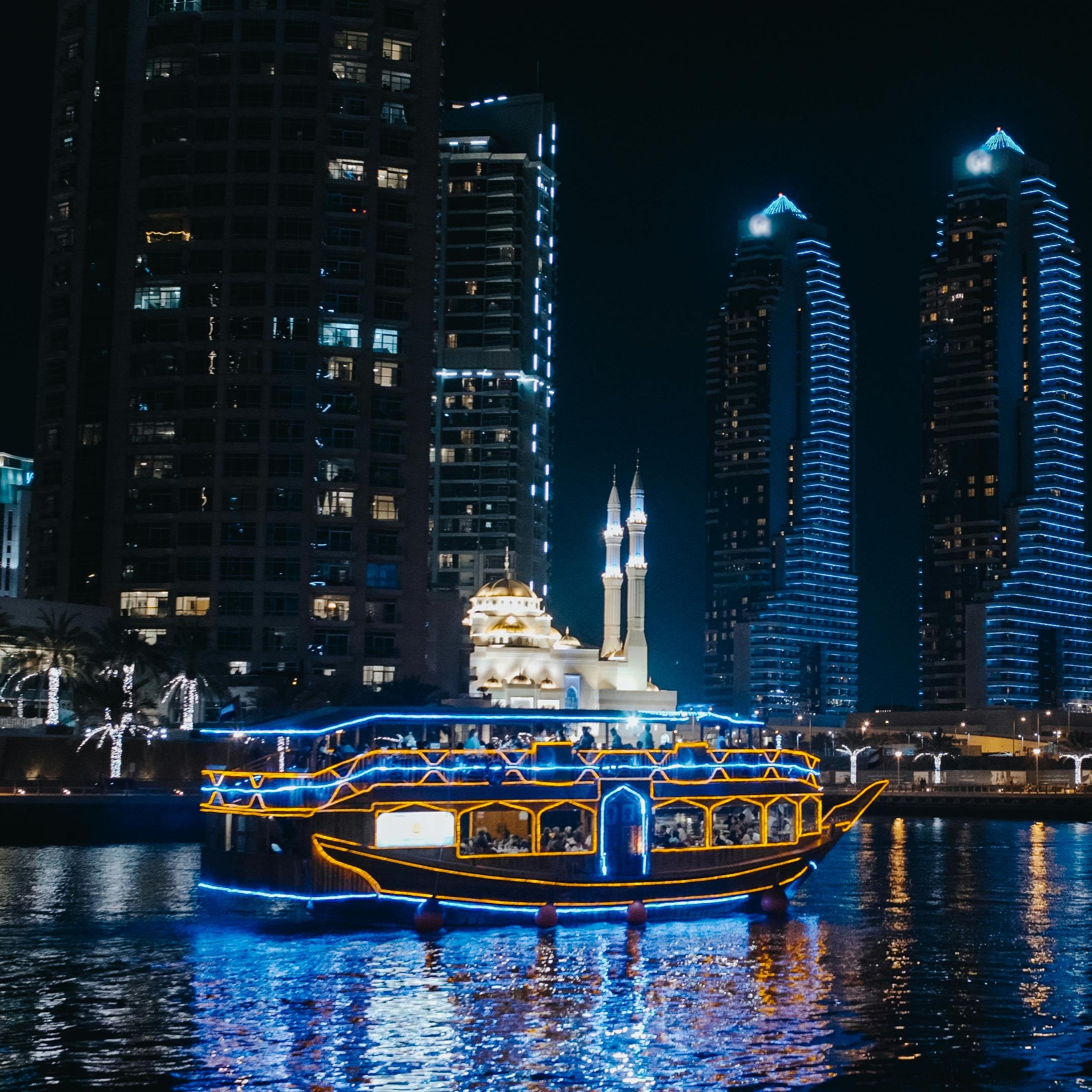 Dubai Marina dhow dinner cruise at night with skyline lights and reflections