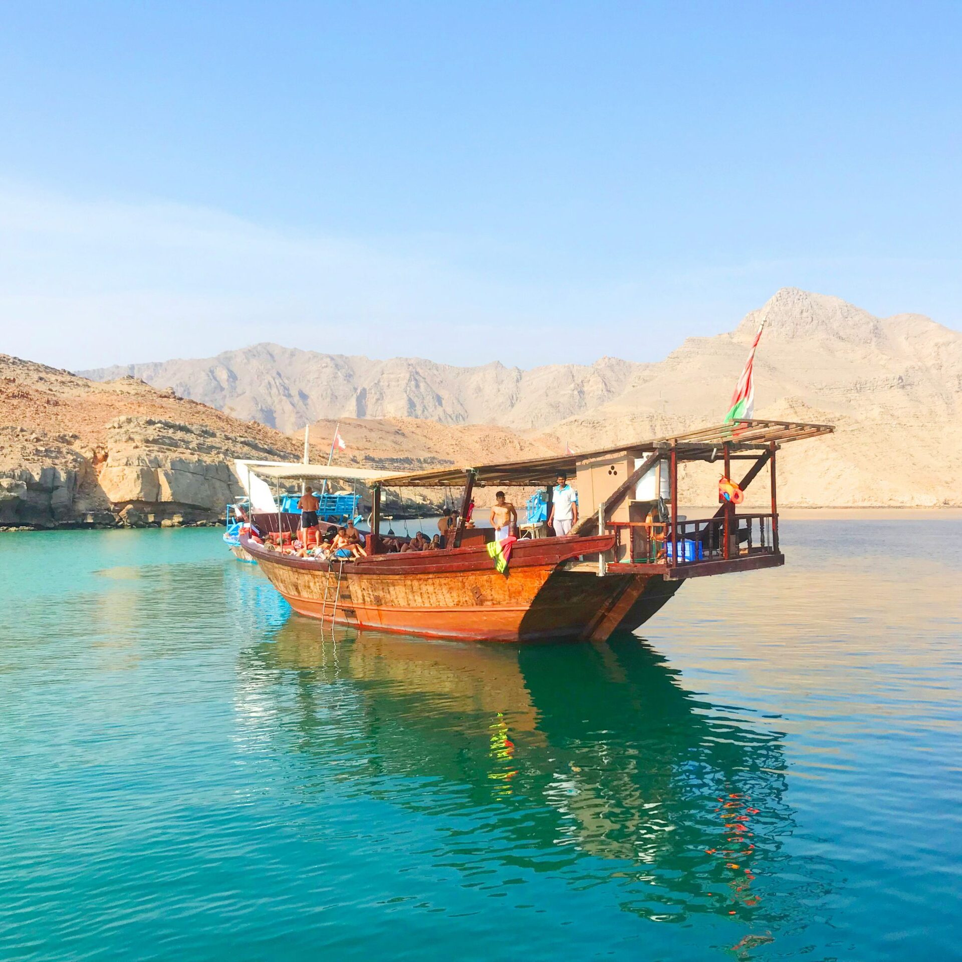 Traditional dhow cruise in Musandam Dibba with mountains and clear turquoise water