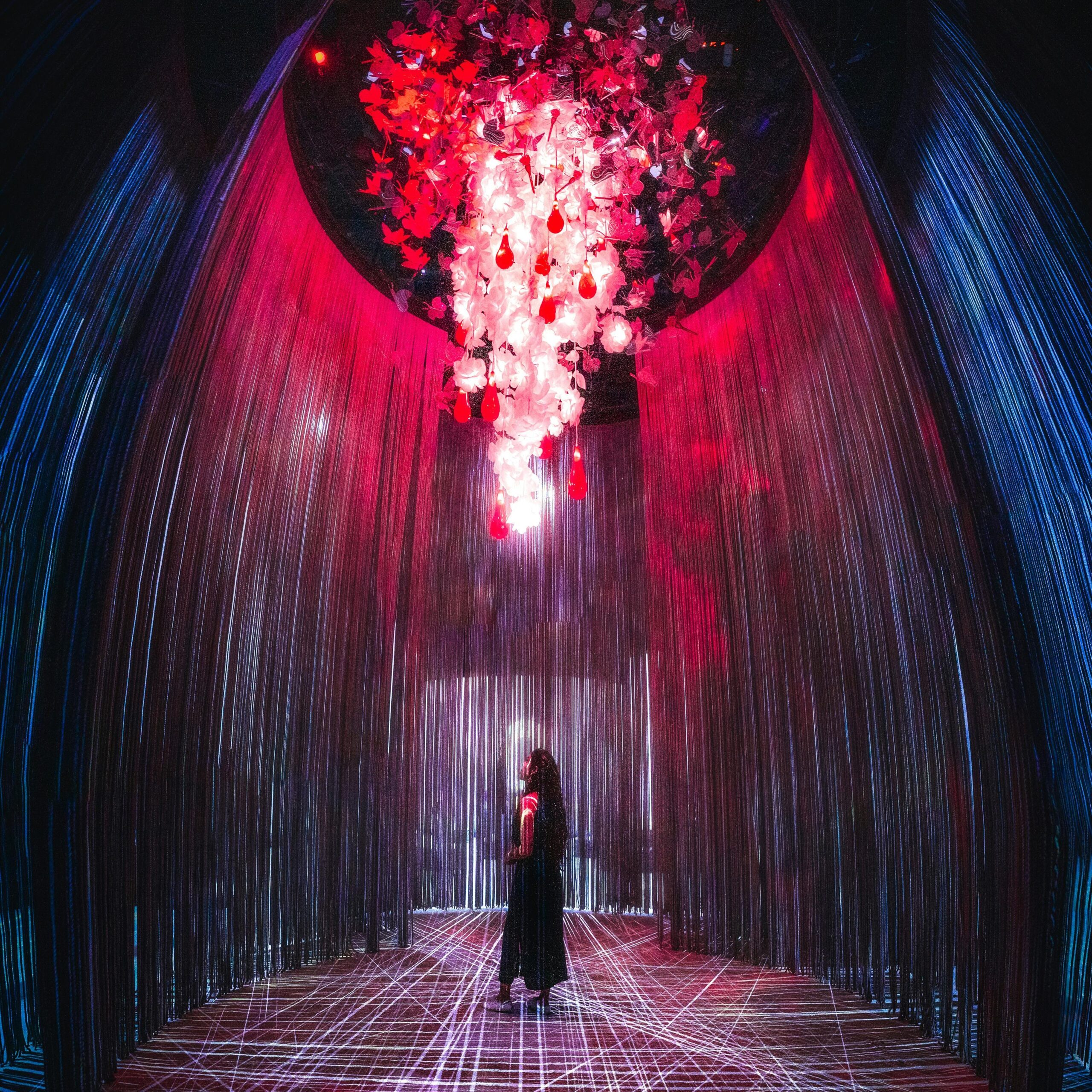 Visitor inside a glowing red illusion tunnel at Museum of Illusions Dubai