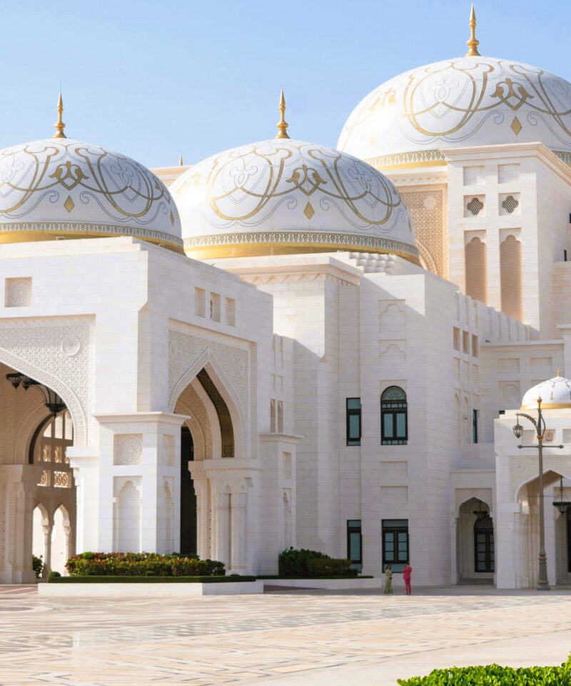 Side view of Qasr Al Watan palace with domes, arches and garden foreground in Abu Dhabi