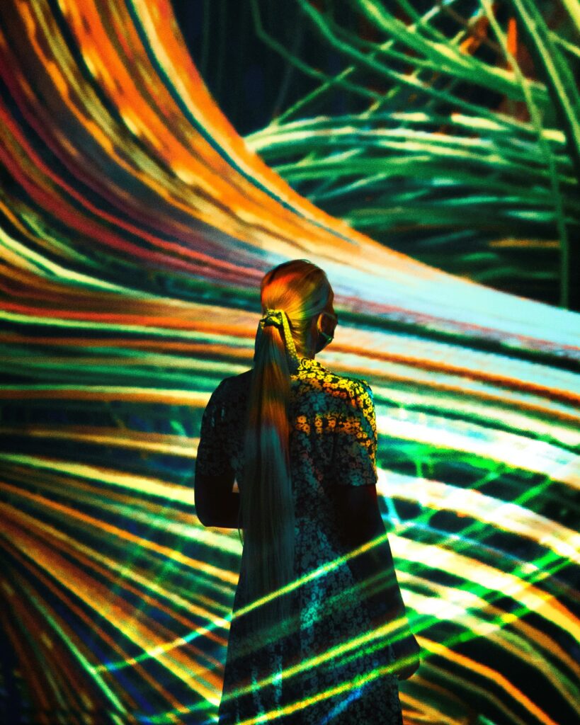 teamLab Abu Dhabi immersive digital art with flowing light trails and visitor